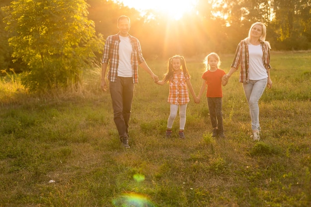 Happy family walking in field and looking at sunset