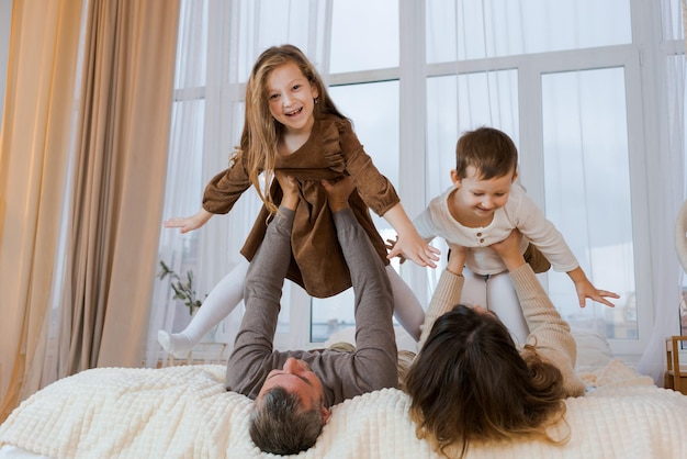 Happy family when mom and dad spend time at home together with two children