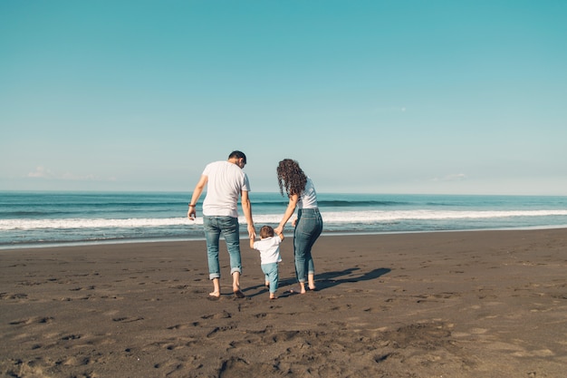 Happy family with baby having fun on beach