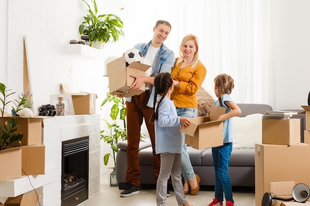 Happy family with cardboard boxes in new house at moving day.