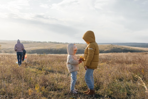 A happy family with children flies a kite and spends time together outdoors in a nature reserve Happy childhood and family holidays Freedom and space