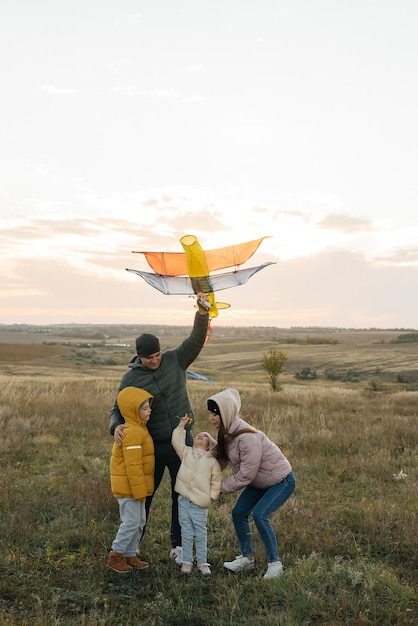 A happy family with children flies a kite and spends time together outdoors in a nature reserve Happy childhood and family holidays Freedom and space