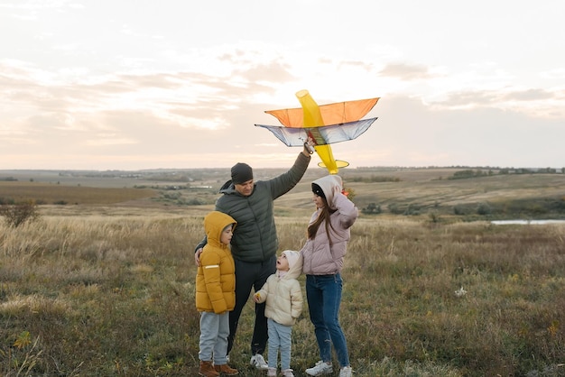 A happy family with children flies a kite and spends time together outdoors in a nature reserve Happy childhood and family holidays Freedom and space