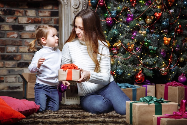 Happy family with Christmas gifts near the Christmas tree