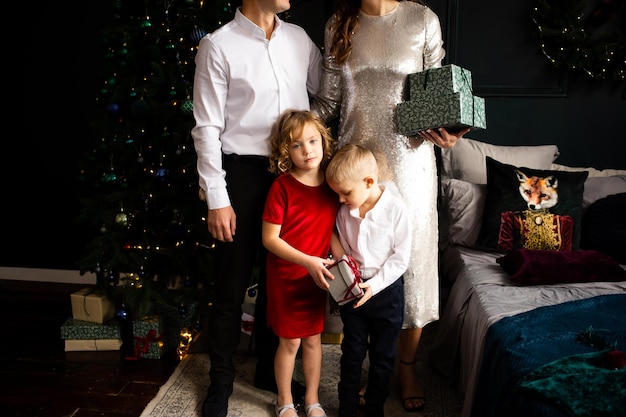 Happy family with gift box near Christmas tree at home Merry Christmas and Happy Holidays