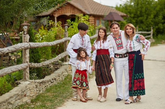 Photo happy family with kids in traditional romanian clothes father mother son and daughters walking outside