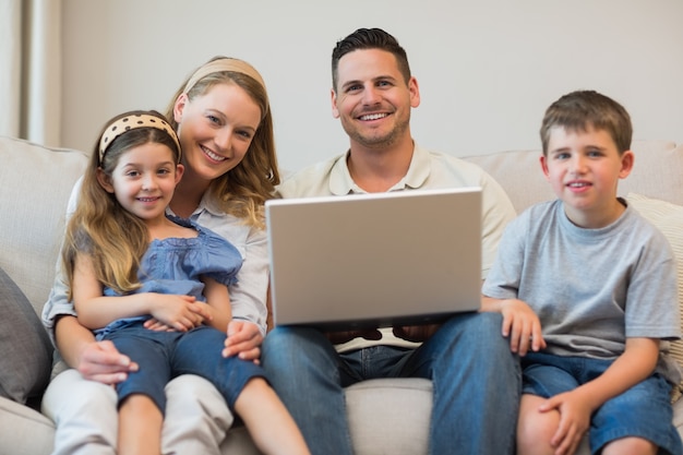 Happy family with laptop on sofa