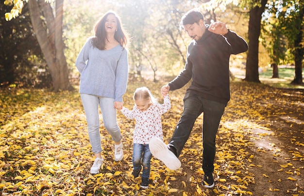 Happy family with little daughter in autumn park outdoor recreation