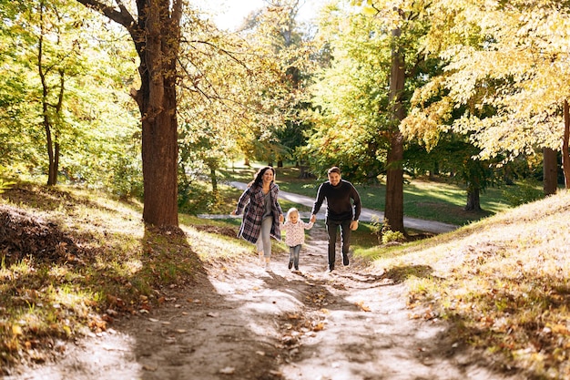 Happy family with little daughter in autumn park outdoor recreation