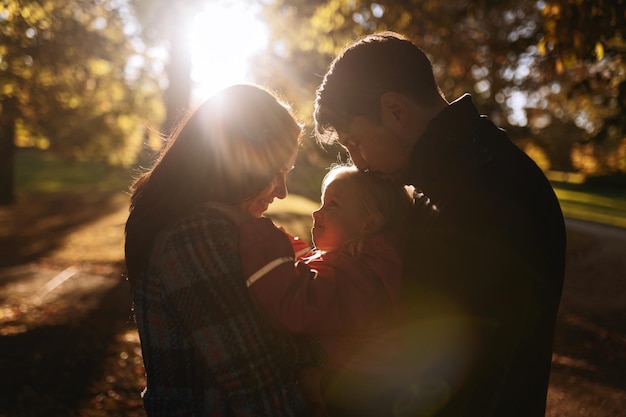 Happy family with little daughter in autumn park outdoor recreation