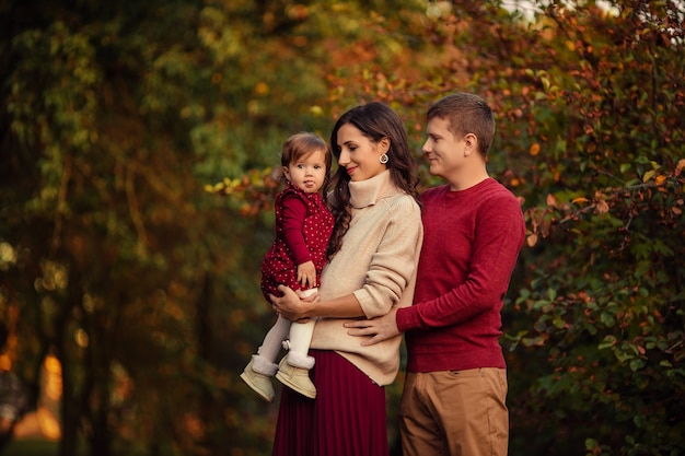 Happy family with little daughter having fun on a walk in the park