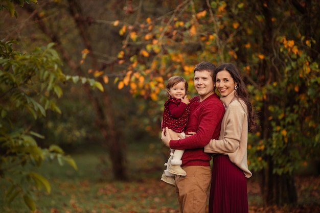 Happy family with little daughter having fun on a walk in the park