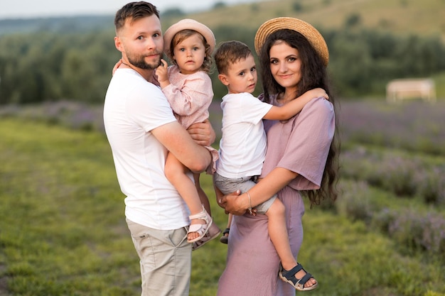 Happy family with little kids at the lavender field loving dad hold in arms adorable daughter