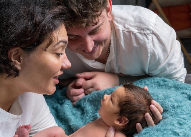 Happy family with a newborn baby Loving mother and father tenderly hold their son in their arms