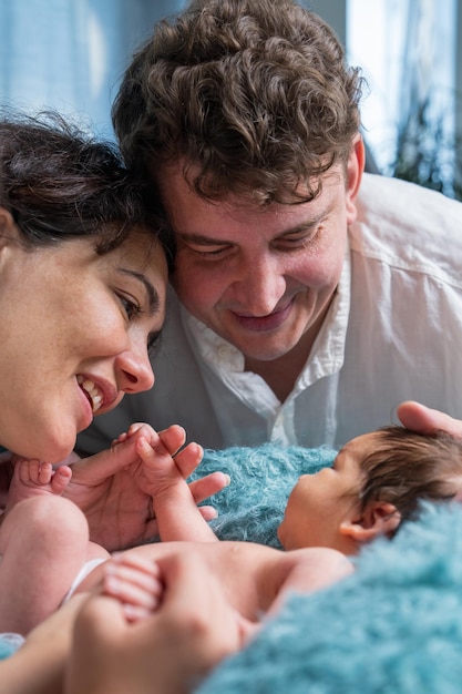 Happy family with a newborn baby Loving mother and father tenderly holding son