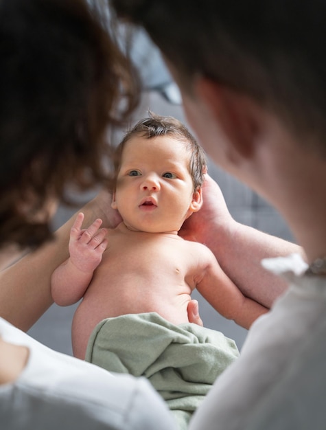 Happy family with a newborn baby Mom and dad look tenderly at the child View through parents