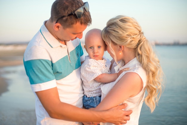 A happy family with a small child on the background of a beautiful sea sunset Anapa Russia