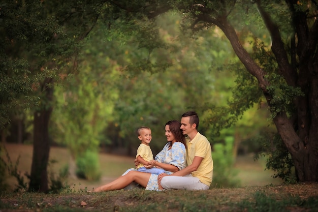 Happy family with a small child on a walk in the park