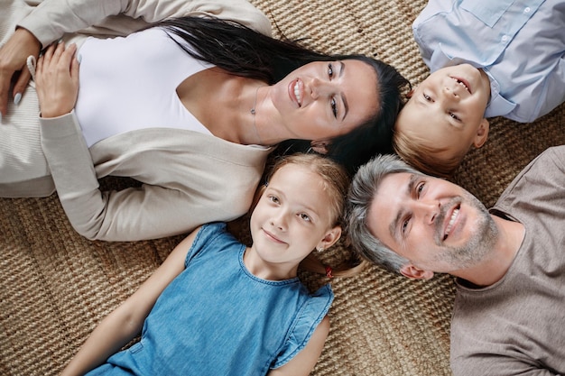 Happy family with two children lying on the floor