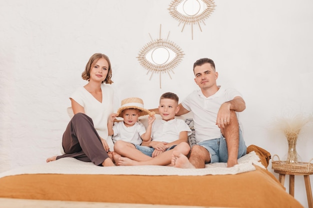 happy family with two children sit on the bed