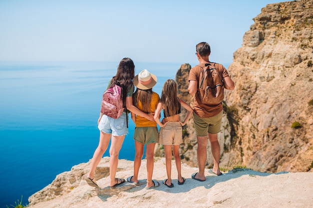 Happy family with two girks hiking in mountains