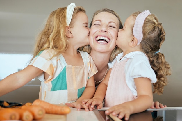 Happy family and young girls kiss mother in joyful face smile celebrating mothers day at home Sisters kissing mom on the cheek in cute playful fun celebration for love and affection in the kitchen