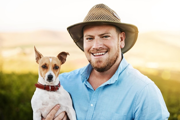 Photo happy farm and portrait of man with dog for pet training in agro sustainable or nature environment field smile and male agriculture worker bonding with jack russell puppy in texas countryside