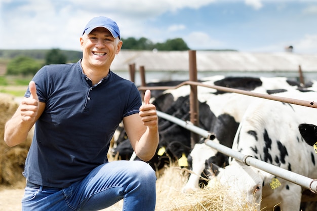 Happy farmer is working on cow farm