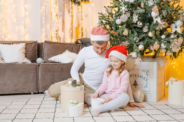 Happy father and children at home near Christmas tree New Year and Christmas