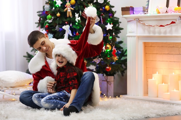 Happy father and daughter have fun in the decorated Christmas room