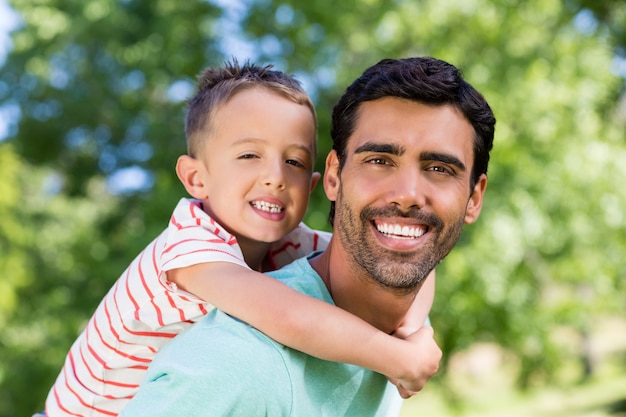 Happy father giving piggyback ride to his son