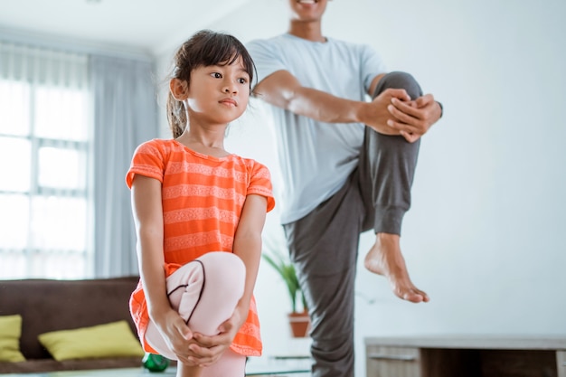 Happy father and kid doing exercise together. portrait of healthy family workout at home. man and his daughter sport