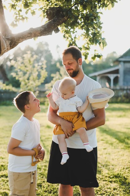 Happy father playing with his children outside in the park