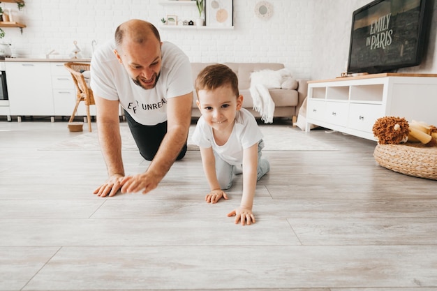 Happy father plays catchup with children on the floor father with children crawling on the floor