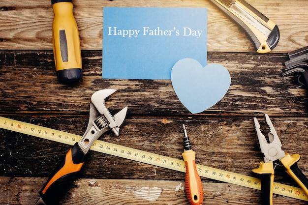 Happy father`s day background concept. Top view of construction handy tools on the wooden background.