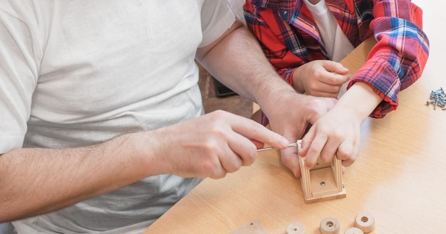 Happy father's day and childhood concept Closeup of a father and a boy son in glasses work with hand