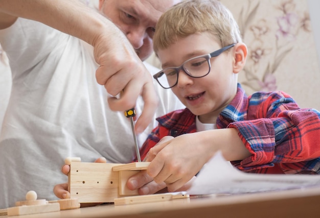 Happy father's day and childhood concept Father and sonboy in glasses work with hand tools using