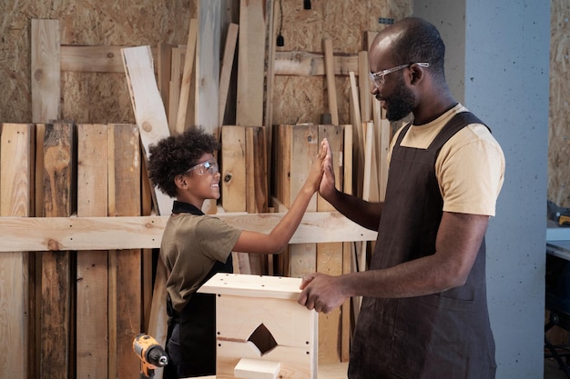 Happy father and son building birdhouse