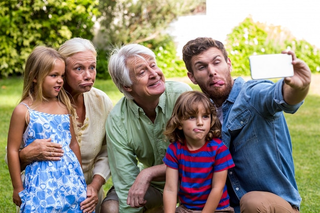 Happy father taking selfie with family in yard