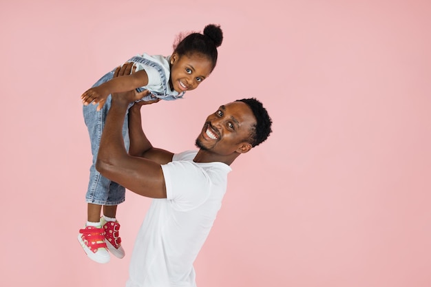 Happy fatherhood Cheerful african dad holding his cute daughter on hands pretending she are flying