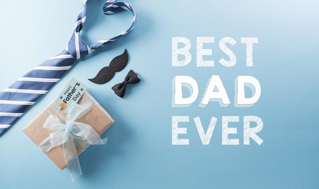 Happy Fathers Day background concept with gift box decorated bow tie necktie and mustache on bright pastel background