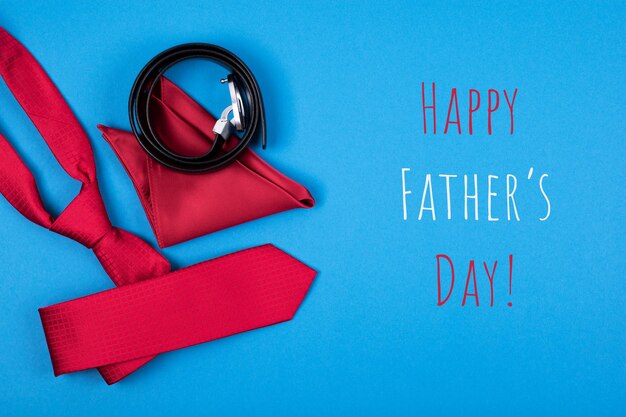 Photo happy fathers day greeting card with red neck tie pocket square and belt on blue background