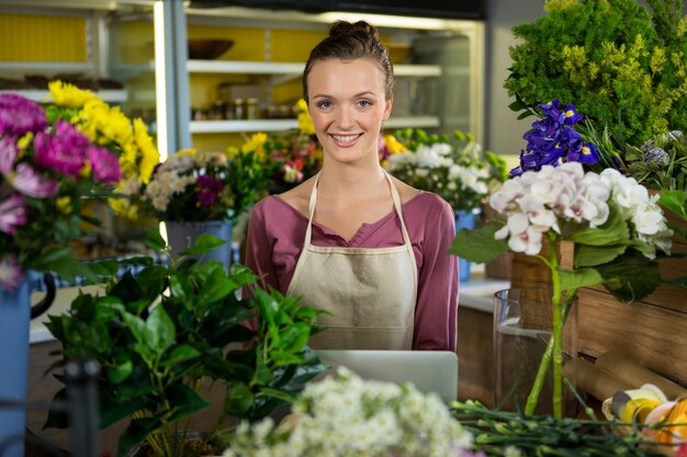 Happy female florist standing in flower shop