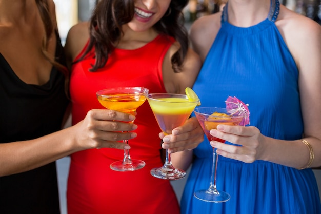 Photo happy female friends holding glass of cocktail