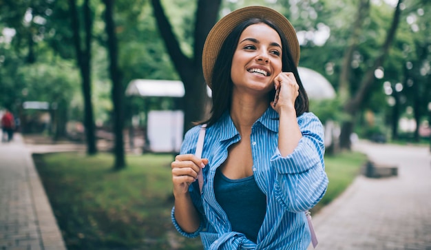 Happy female tourist using internet for making online call via cellphone application for communicate