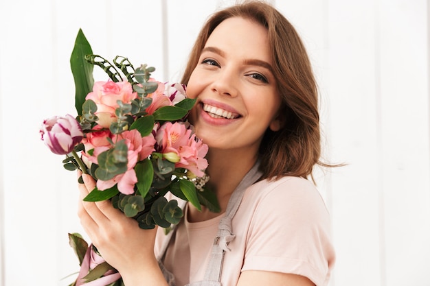 Happy florist woman standing with flowers