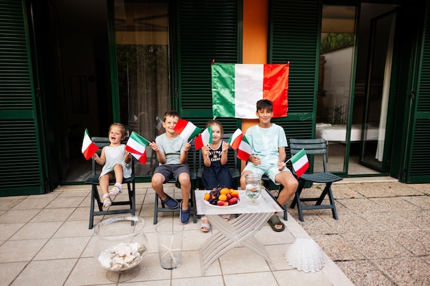 Happy four kids with italian flags celebrating Republic Day of Italy