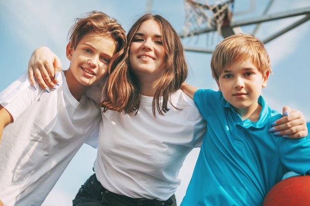 Happy friends are hugging each other on the basketball court. Sports, games, and education.