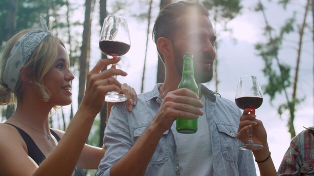 Happy friends clinking glasses outdoors Fellows drinking alcohol outside