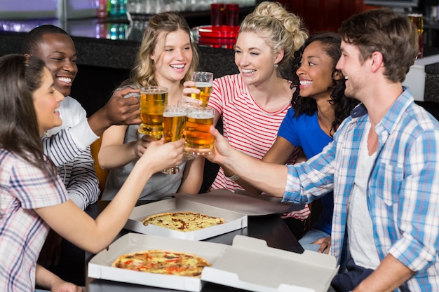 Happy friends having a drink and pizza